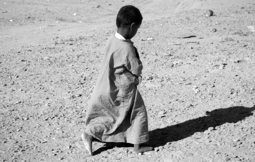 Menschenrechte kleiner Junge im Sand Barfuss