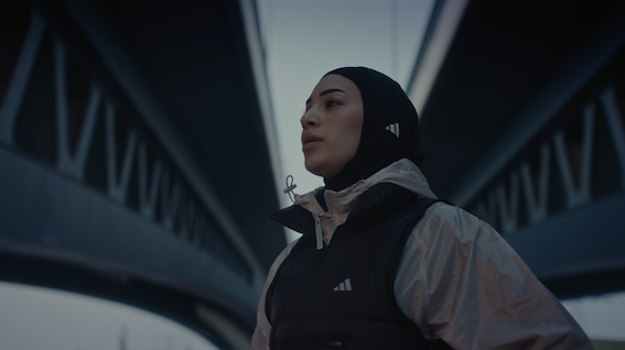 muslimische Frau in adidas Sportkleidung inklusive adidas Sportkopftuch